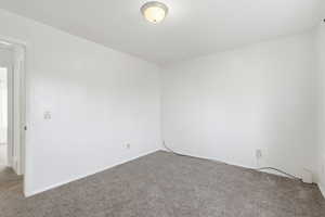 Carpeted spare room with baseboards
