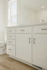 Bathroom view of wood finished floors and vanity