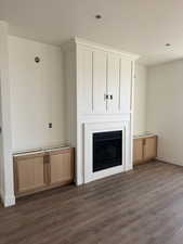 Unfurnished living room with a fireplace, dark wood-type flooring, and a textured ceiling
