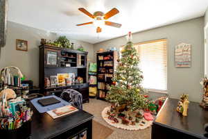 Home office featuring a ceiling fan and light carpet