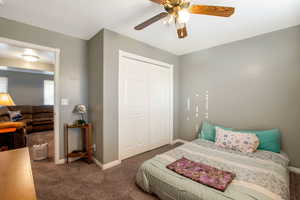Carpeted bedroom with a closet and a ceiling fan