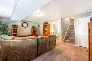 Living room with carpet and stairs