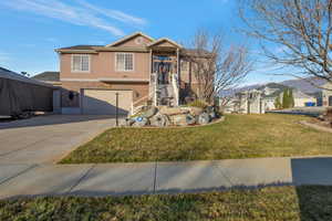 View of front of house featuring stucco siding, brick siding, concrete driveway, a garage, and a front yard