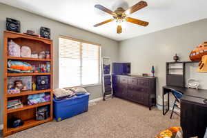 Bedroom featuring light carpet and a ceiling fan