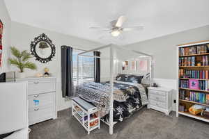 Bedroom featuring ceiling fan and dark carpet