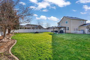 Fenced backyard featuring a gazebo and a patio area