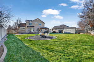 Rear view of house with a gazebo, a patio, a fenced backyard, stucco siding, and an outbuilding