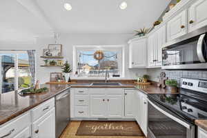Kitchen with appliances with stainless steel finishes, white cabinets, recessed lighting, decorative backsplash, and light tile patterned floors
