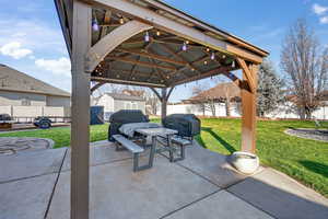 Fenced backyard featuring a shed, a patio area, a gazebo, and area for grilling