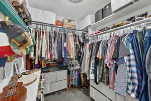 Walk in closet featuring dark colored carpet