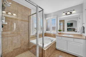 Ensuite bathroom with vanity, a shower stall, a bath, and light tile patterned flooring