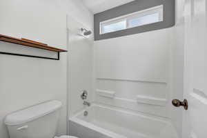 Full bathroom featuring shower / tub combination and toilet