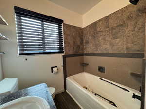 Full bathroom featuring a bathtub, dark wood-type flooring, and a shower