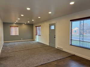 Entrance foyer featuring recessed lighting and dark colored carpet