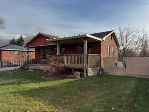 Rear view of house featuring a gate, brick siding, and a wooden deck