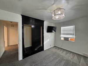 Unfurnished bedroom featuring dark carpet