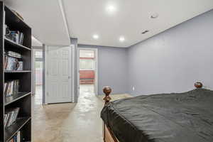 Bedroom with concrete floors and recessed lighting