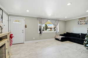 Living room featuring marble look tile flooring, ornamental molding, and recessed lighting