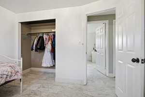 Bedroom with a closet and light marble finish floors