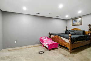 Bedroom with concrete flooring and recessed lighting
