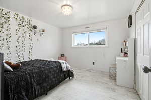 Bedroom with baseboards and light marble finish floors