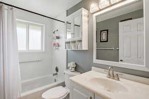 Full bath with shower / bath combo with shower curtain and vanity