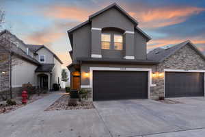 Traditional-style house with concrete driveway, stone siding, and stucco siding