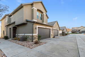 View of front of home with stone siding, stucco siding, driveway, and a residential view