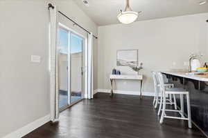 Dining space featuring dark wood finished floors and baseboards