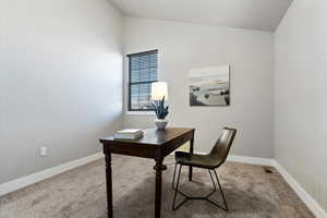 Office space featuring light carpet and lofted ceiling