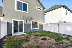 Back of property featuring a gate and stucco siding