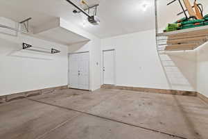 Garage with a garage door opener and baseboards