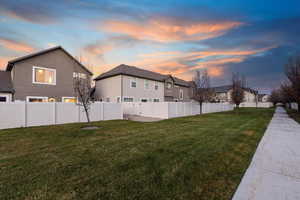 Yard at dusk featuring a fenced backyard and a residential view
