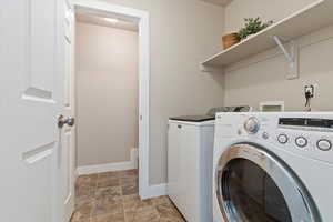 Laundry room with stone finish floors and separate washer and dryer