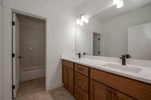 Bathroom with double vanity and baseboards