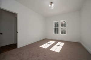 Carpeted empty room featuring baseboards