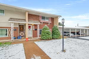 View of front of home with brick siding and covered porch