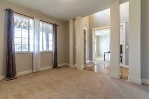 Spare room with light colored carpet and baseboards