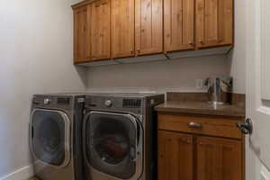 Laundry area with cabinet space and washing machine and clothes dryer