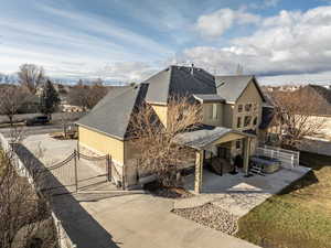 View of side of home with a gate, roof with shingles, stucco siding, and driveway