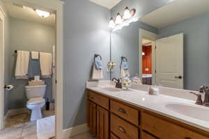 Bathroom with double vanity and light tile patterned floors