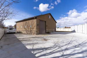 View of property exterior featuring stone siding and an outbuilding