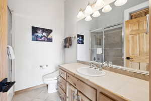 Full bathroom with vanity, light tile patterned floors, and a shower with shower door