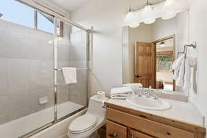 Bathroom featuring plenty of natural light, vanity, and enclosed tub / shower combo