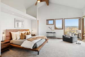 Carpeted bedroom featuring high vaulted ceiling, ceiling fan, and beam ceiling