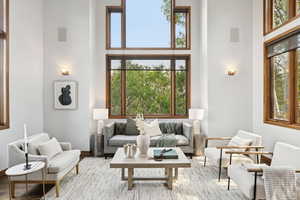 Living area featuring a high ceiling, wood finished floors, and plenty of natural light