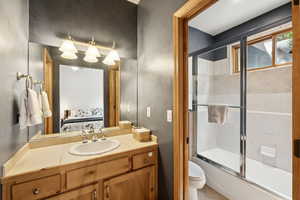 Bathroom with shower / bath combination with glass door, vanity, and ensuite bath
