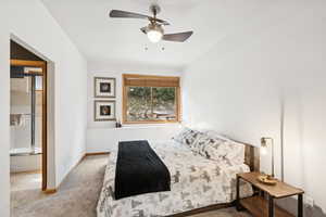 Bedroom with carpet floors, a ceiling fan, and ensuite bathroom
