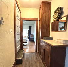 Corridor with a textured wall and dark wood finished floors