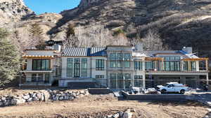 Rear view of house with a chimney, a mountain view, a metal roof, and a standing seam roof